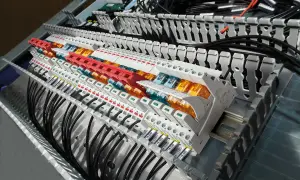 W panelu sterowania widać rzędy modułów, gdzie stycznik i przekaźnik współpracują, tworząc skomplikowaną sieć połączeń elektrycznych.