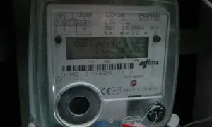 Cyfrowy licznik energii elektrycznej z widoczną czerwoną lampką w liczniku prądu, migającą podczas pracy.