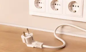 Wtyczka leży obok gniazdek elektrycznych. Zastanawiasz się, jakie powinno być napięcie w sieci, by wszystko działało bezpiecznie?