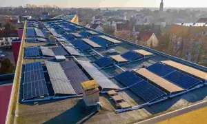 Panele fotowoltaiczne na dachu budynku. To rozwiązanie, które pozwala na pozyskiwanie energii ze słońca. Zastanawiasz się, perc co to? To właśnie panele PV!