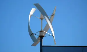 Wiatrak o pionowej osi obrotu na tle błękitnego nieba. Zastanawiasz się, ile wiatrak produkuje energii?