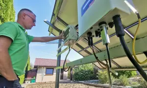 Mężczyzna sprawdza instalację fotowoltaiczną. Czy prąd z fotowoltaiki jest wykorzystywany na bieżąco? To kluczowe pytanie przy optymalizacji zużycia energii.