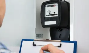 Inspektor spisuje odczyt licznika prądu, który może sugerować, że nowe liczniki prądu oszukują.