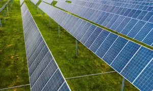 Rzędy paneli fotowoltaicznych na zielonej łące. To idealne miejsce na depozyt prosumencki, księgowanie energii odnawialnej.