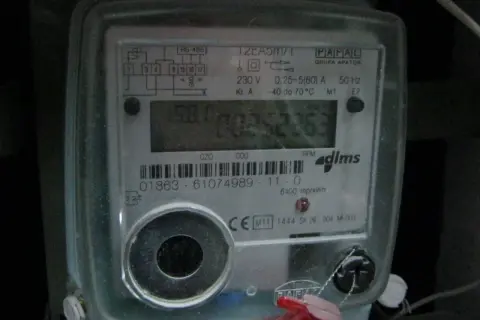 Cyfrowy licznik energii elektrycznej z widoczną czerwoną lampką w liczniku prądu, migającą podczas pracy.