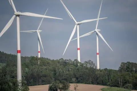 Wiatraki na tle zielonych wzgórz. Zastanawiasz się, ile wiatrak produkuje energii dziennie?
