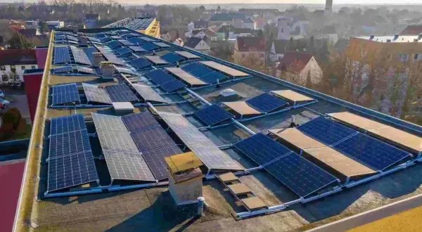 Panele fotowoltaiczne na dachu budynku. To rozwiązanie, które pozwala na pozyskiwanie energii ze słońca. Zastanawiasz się, perc co to? To właśnie panele PV!