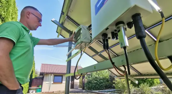 Mężczyzna sprawdza instalację fotowoltaiczną. Czy prąd z fotowoltaiki jest wykorzystywany na bieżąco? To kluczowe pytanie przy optymalizacji zużycia energii.