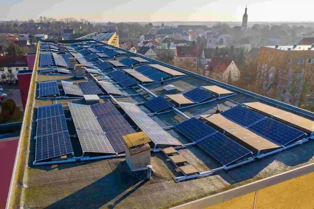 Panele fotowoltaiczne na dachu budynku. To rozwiązanie, które pozwala na pozyskiwanie energii ze słońca. Zastanawiasz się, perc co to? To właśnie panele PV!