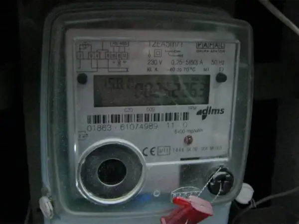 Cyfrowy licznik energii elektrycznej z widoczną czerwoną lampką w liczniku prądu, migającą podczas pracy.