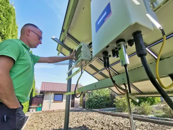 Mężczyzna sprawdza instalację fotowoltaiczną. Czy prąd z fotowoltaiki jest wykorzystywany na bieżąco? To kluczowe pytanie przy optymalizacji zużycia energii.