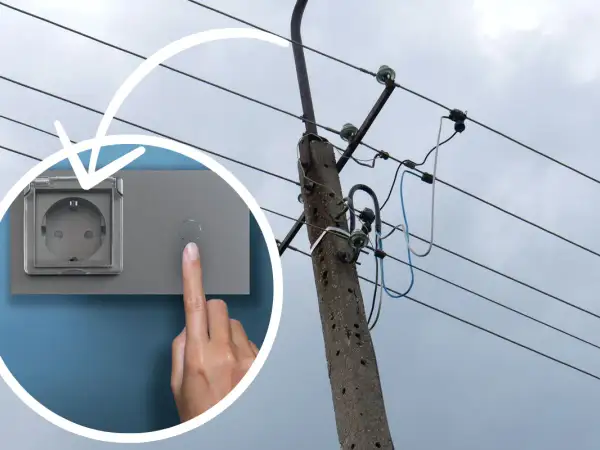 Palec naciska przycisk obok gniazdka z klapką. W tle słup energetyczny z przewodami. To oznaczenie l.